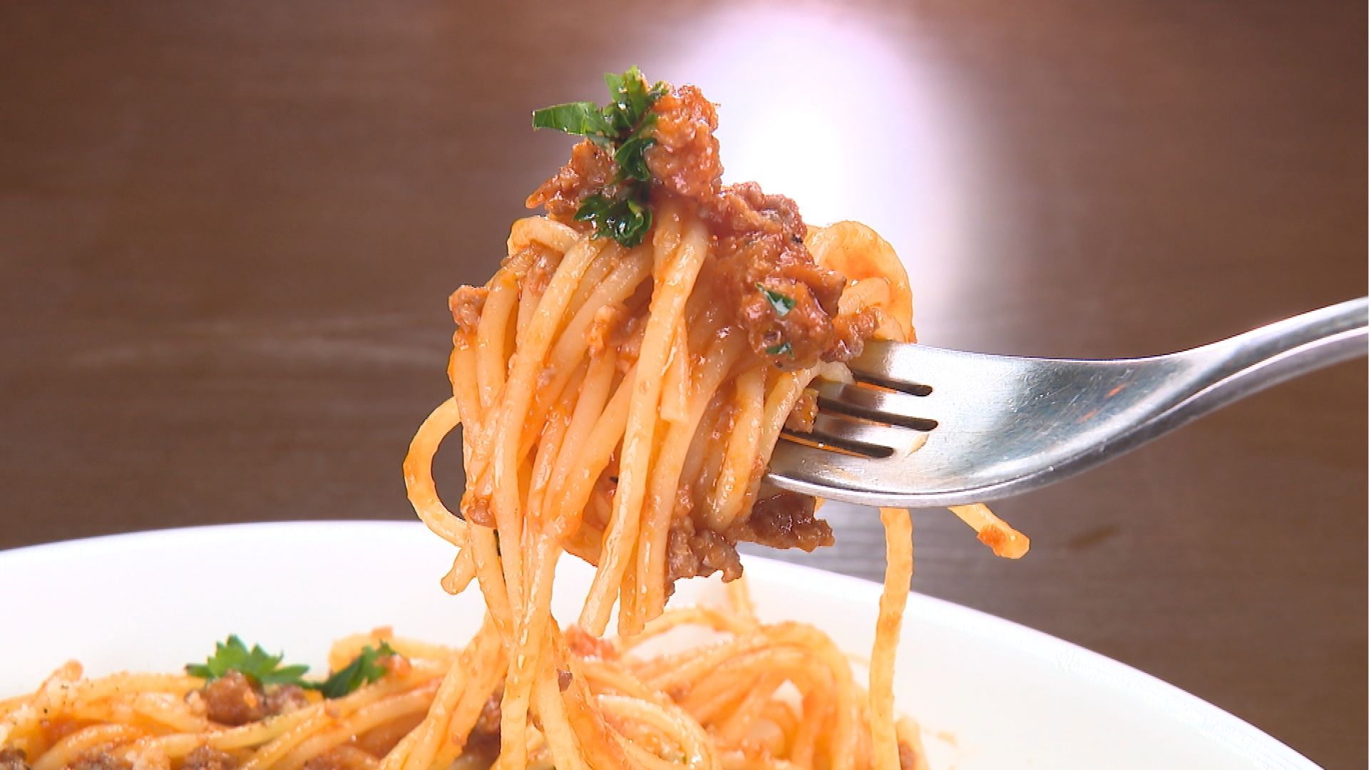 スパゲッティボロネーゼソースをフォークで持ち上げているところ