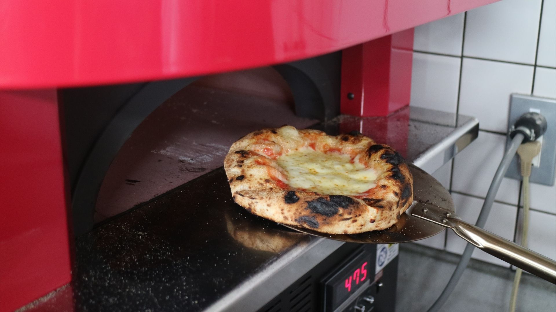 窯に入れられるピザ